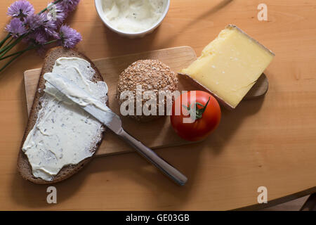 Cheese spreading on slice of brown bread in the kitchen Stock Photo