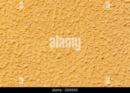 Plastered concrete surface with an uneven rough texture, painted in yellow color Stock Photo