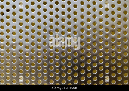 Metal stainless steel shiny flat grille with round holes and scratches on the surface Stock Photo