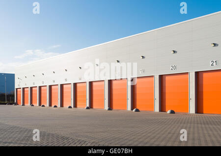 exterior of a commercial warehouse with orange roller doors Stock Photo