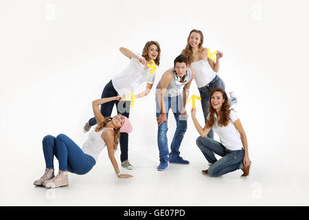 Group of friends four girls and a boy. The team of four beautiful young woman with yellow arrow points to the lone handsome guy. Stock Photo