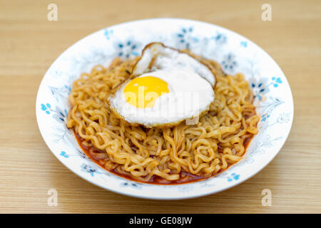 Korean noodles(Ramen) in flower bowl on wooden table. Stock Photo