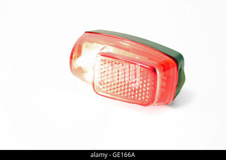 A red bicycle taillight turned on on a white background. Stock Photo