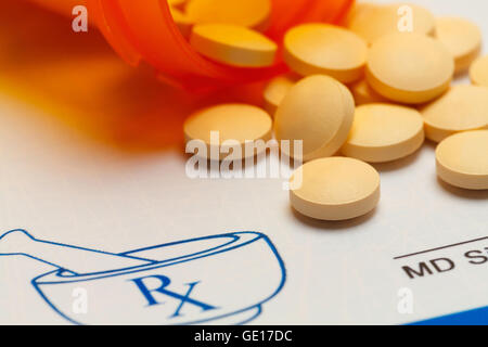 Orange Pills Spilled on RX Medicine Prescription Doctors Note. Stock Photo