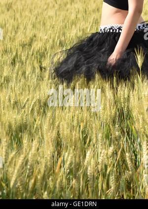 Woman in tutu walking though wheat field Stock Photo