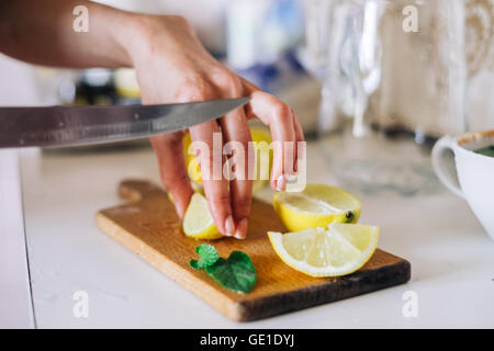 Woman chopping lemon Stock Photo