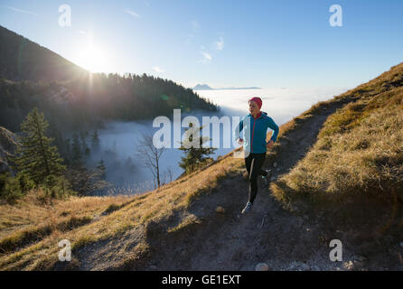 Woman Trail Running in the Mountains above the Clouds, Salzburg, Austria