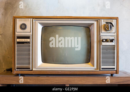 retro tv with wooden case in room with vintage wallpaper on wood table Stock Photo