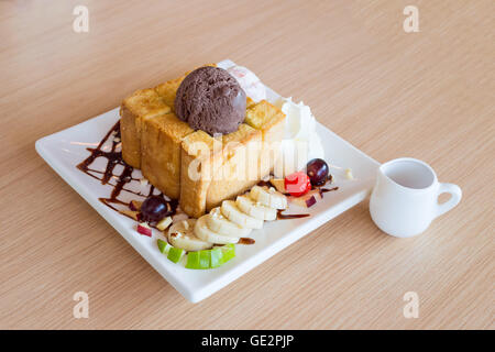 Honey toast and whipping cream with chocolate ice cream on wood background Stock Photo