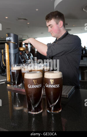 Ireland, Dublin, Ainsfort Street, Guinness Storehouse, Gravity Bar bartender pouring pints of Guinness Stock Photo