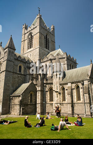 Ireland, Dublin,  visitors in sunshine on lawn of 1038 Christ Church Cathedral Stock Photo