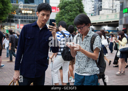 Tokyo, Japan. 22nd July, 2016. Fans try out Pokemon Go in Tokyo's Shibuya district on July 22, 2016, Tokyo, Japan. The Pokemon Go app finally arrived in the land of the Pokemon on Friday 22, July two weeks after its launch in the United States. The release of the app in Japan had been rumoured for the past few days after the leak of details of a partnership deal with McDonald's Japan to create Pokemon Gyms in its 3,000 locations. Nintendo's market value has almost doubled since the app created by Niantic first launched in America. Credit:  Aflo Co. Ltd./Alamy Live News Stock Photo