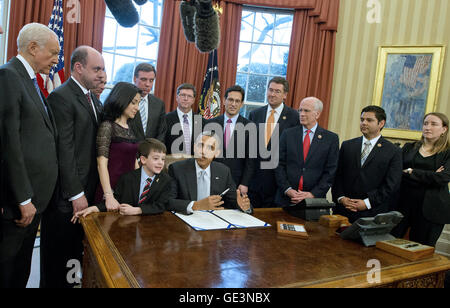 April 3, 2014 - Washington, District of Columbia, United States of America - United States President Barack Obama signs H.R. 2019, the Gabriella Miller Kids First Research Act in the Oval Office of the White House in Washington, DC on Thursday, April 3, 2014. From left to right: U.S. Senator Orrin Hatch (Republican of Utah); Mark Miller, father of Gabriella Miller; U.S. Senator Tim Kaine (Democrat of Virginia); Ellyn Miller, Mother of Gabriella Miller, U.S. Senator Mark Warner (Democrat of Virginia); Jacob Miller, Brother of Gabriella Miller; Mike Gillette, Friend of the Miller Family; U.S Stock Photo