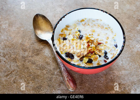Bowl of fresh muesli with a mix of wheat, oats and bran with dried fruit and nuts over stone background, copyspace, top view. Stock Photo