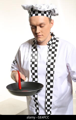 Portrait of young chef in uniform acrid chilli. Stock Photo