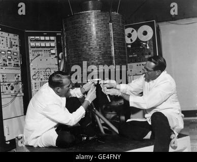 (1965) Engineers Stanley R. Peterson (left) and Ray Bowerman (right), checkout the Early Bird, the world's first communication satellite. NASA launched the satellite built by Hughes Aircraft Corporation on April 6, 1965 at 6:48pm E.S.T. from Complex 17a at Cape Kennedy, Florida. Early Bird was built for the Communications Satellite Corporation and weighed about 85 pounds after being placed in a synchronous orbit of 22,300 miles above the earth. It was positioned over the Atlantic to provide 240 two-way telephone channels or 2-way television between Europe and North America. The outer surface o Stock Photo