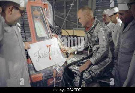 Astronaut John Glenn and technicians inspect artwork that will be painted on the outside of his Mercury spacecraft. John Glenn nicknamed his capsule &quot;Friendship 7&quot;. On February 20, 1962 astronaut John H. Glenn Jr. lifted off into space aboard his Mercury Atlas (MA-6) rocket and became the first American to orbit the Earth. After orbiting the Earth 3 times, Friendship 7 landed in the Atlantic Ocean 4 hours, 55 minutes and 23 seconds later, just East of Grand Turk Island in the Bahamas. Glenn and his capsule were recovered by the Navy Destroyer Noa, 21 minutes after splashdown.  Image  Stock Photo