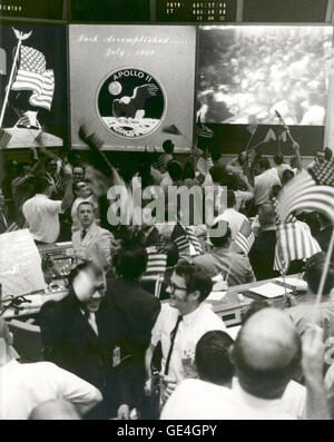 (July 24, 1969) Overall view of the Mission Operations Control Room in the Mission Control Center, Building 30, Manned Spacecraft Center, showing the flight controllers celebrating the successful conclusion of the Apollo 11 lunar landing mission.  Image # : S-69-40023 Stock Photo