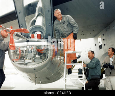 Jay L. King, Joseph D. Huxman and Orion D. Billeter assist NASA research pilot Milt Thompson (on the ladder) into the cockpit of the M2-F2 lifting body research aircraft at the NASA Flight Research Center (now the Armstrong Flight Research Center). The M2-F2 is attached to a wing pylon under the wing of NASA's B-52 mothership.   Image # : EC66-1154 Date: February 1, 1966 Stock Photo