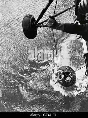 A U.S. Marine helicopter recovery team hoists astronaut Alan Shepard from his Mercury spacecraft after a successful flight and splashdown in the Atlantic Ocean. On May 5th 1961, Alan B. Shepard Jr. became the first American to fly into space. His Freedom 7 Mercury capsule flew a suborbital trajectory lasting 15 minutes 22 seconds. His spacecraft landed in the Atlantic Ocean where he and his capsule were recovered by helicopter and transported to the awaiting aircraft carrier U.S.S. Lake Champlain.  Image # : S61-02723 Stock Photo