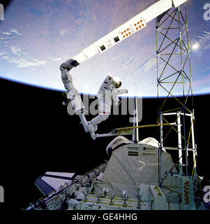 Astronaut Jerry L. Ross, anchored to the foot restraint on the Remote Manipulator System (RMS), approaches the tower-like Assembly Concept for Construction of Erectable Space Structures (ACCESS) device. The structure was just deployed by Ross and astronaut Sherwood Spring as the Atlantis flies over white clouds and blue ocean waters of the Atlantic.  Image # : 61B-41-019  Date: December 1, 1985 Stock Photo
