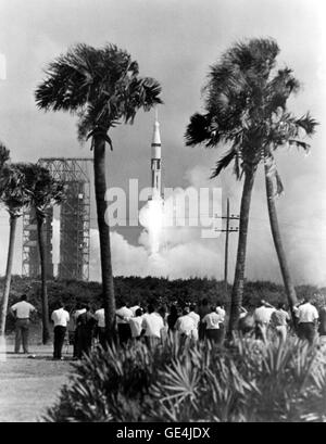 A photograph captures the launch of the Saturn V rocket carrying the ...