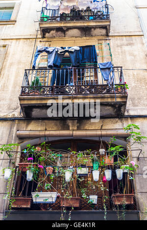 Balconies with many flower pots and hanging clothes in the old town of Barcelona, Catalonia, Spain Stock Photo