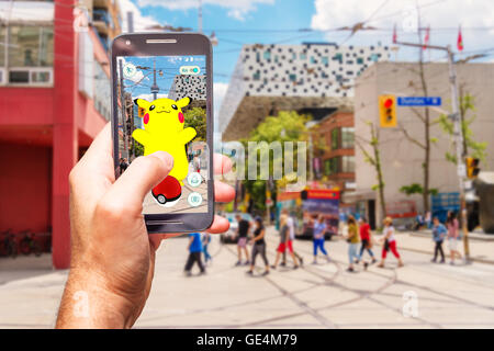 An Android user plays Pokemon Go (montage) Stock Photo