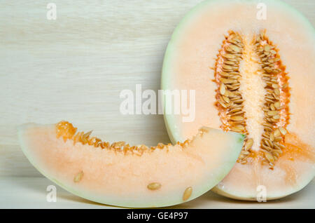 Sliced cantaloupe or Charentais melon or Cucumis melo var. cantalupensis on wooden board background Stock Photo