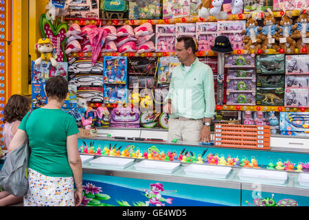 Toys on display as prizes at Hook-a-duck / Duck Pond Game, traditional fairground stall game at travelling funfair Stock Photo