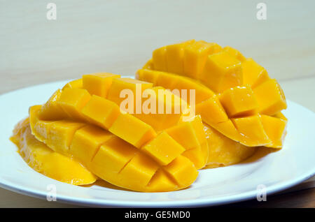 Beautiful nicely cut yellow mango on wooden board background Stock Photo