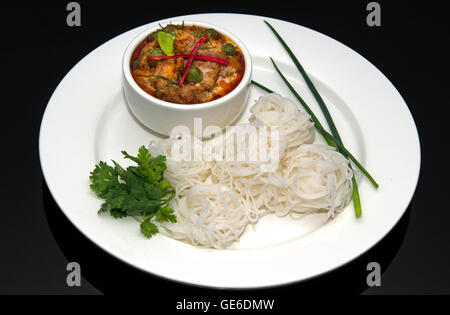 Thai Red Beef curry, white rice noodles on black background Stock Photo