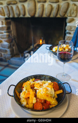 Huevos rotos with chorizo. Rascafria, Madrid province, Spain. Stock Photo