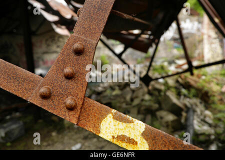 Rivets in joint between old rusty steel beams in collapsing roof. Stock Photo