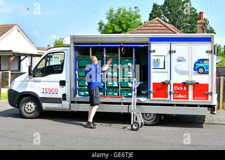 Tesco Supermarket home delivery van driver unloading groceries onto trolley at customers street address in residential road Essex England UK Stock Photo