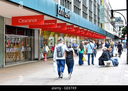 John Lewis Department store Oxford Street stores summer clearance red sale banners hanging from pavement canopy West End London England UK