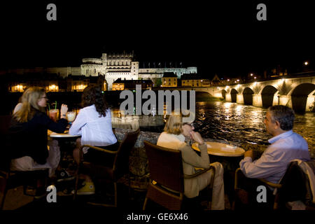 People sit at a bar terrace looking out at the Amboise castle and the Loire river in France, 26 June 2008. Stock Photo