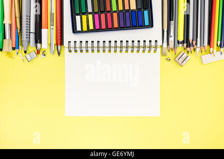bright office and school stationary with notebook on yellow writing desk background Stock Photo