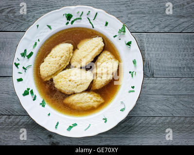 Homemade chicken broth with semolina dumplings on a slate gray wooden background Stock Photo