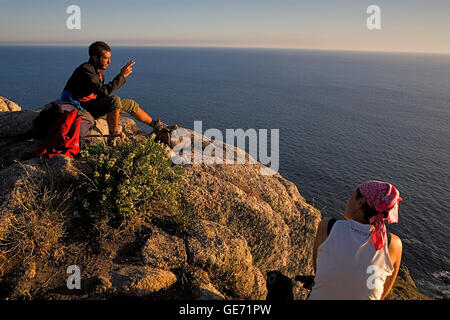 Pilgrims in Cape Finisterre enjoying a sunset. Finisterre.Coruña province.Spain. Camino de Santiago Stock Photo