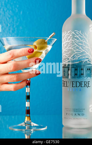 Belvedere Vodka and a two olive martini with woman's hand holding glass Stock Photo