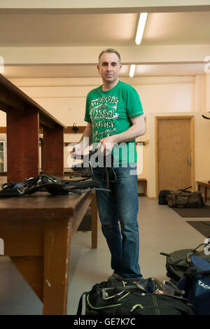 horse racing locker room, stud room where the jockeys change into their outfits with a locker room attendant and saddles Stock Photo