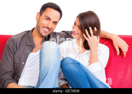 Portrait of smiling young man with girlfriend. Loving couple relaxing on sofa. They are spending leisure time isolated over whit Stock Photo
