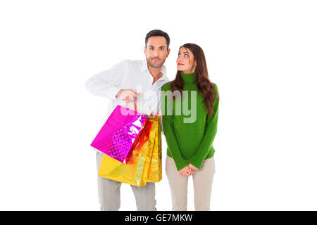 A photo of happy young woman looking at man carrying shopping bags. Male and female partners are in casuals. They are standing i Stock Photo