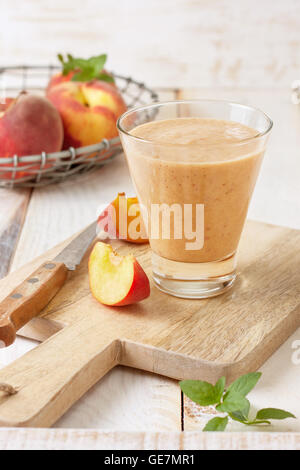 peach smoothie in glass, fresh peaches on a wooden background Stock Photo