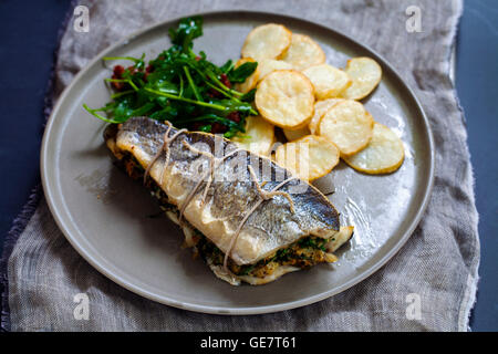 Stuffed sea bass with salad and potatoes Stock Photo