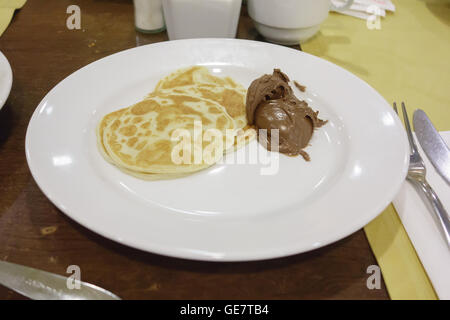 pancakes with chocolate on a white plate is served for dinner at the restaurant Stock Photo
