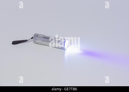 small working flashlight on a white background with a beam of light Stock Photo