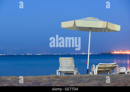 beach at night on the beach with umbrellas sun beds and chairs Stock Photo