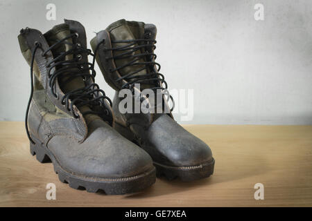 Old jungle boot still life on wood background Stock Photo